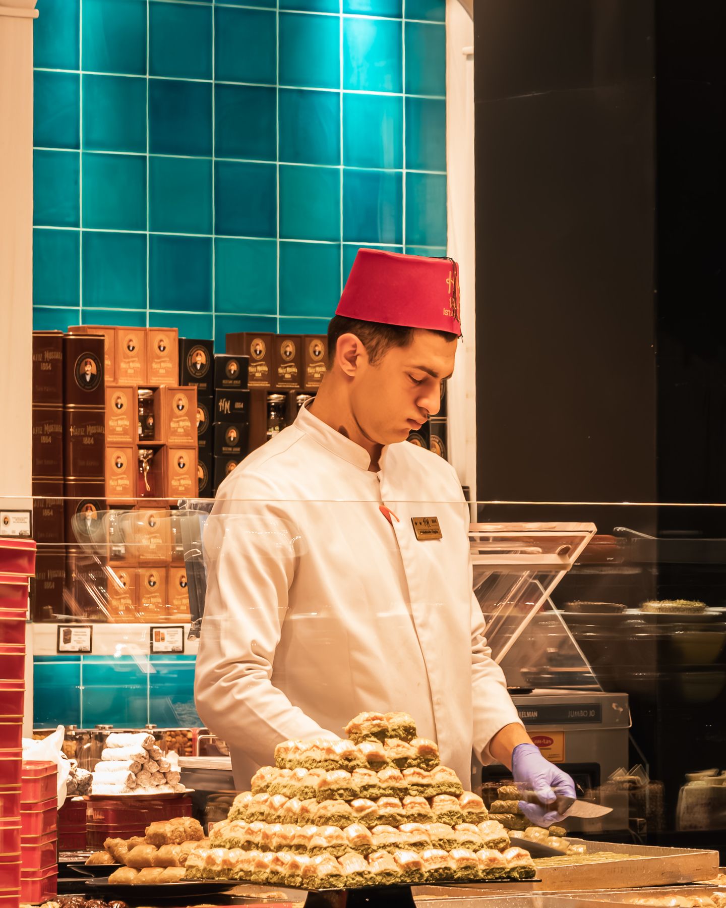 Pastry maker in a red fez serving baklava, Istanbul