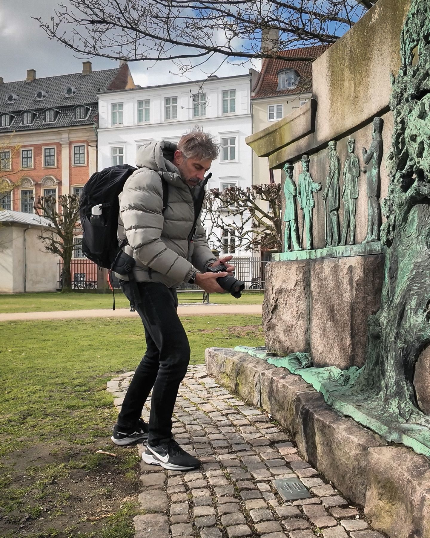 Marcelo Gori photographing a bronze relief in a Copenhagen park